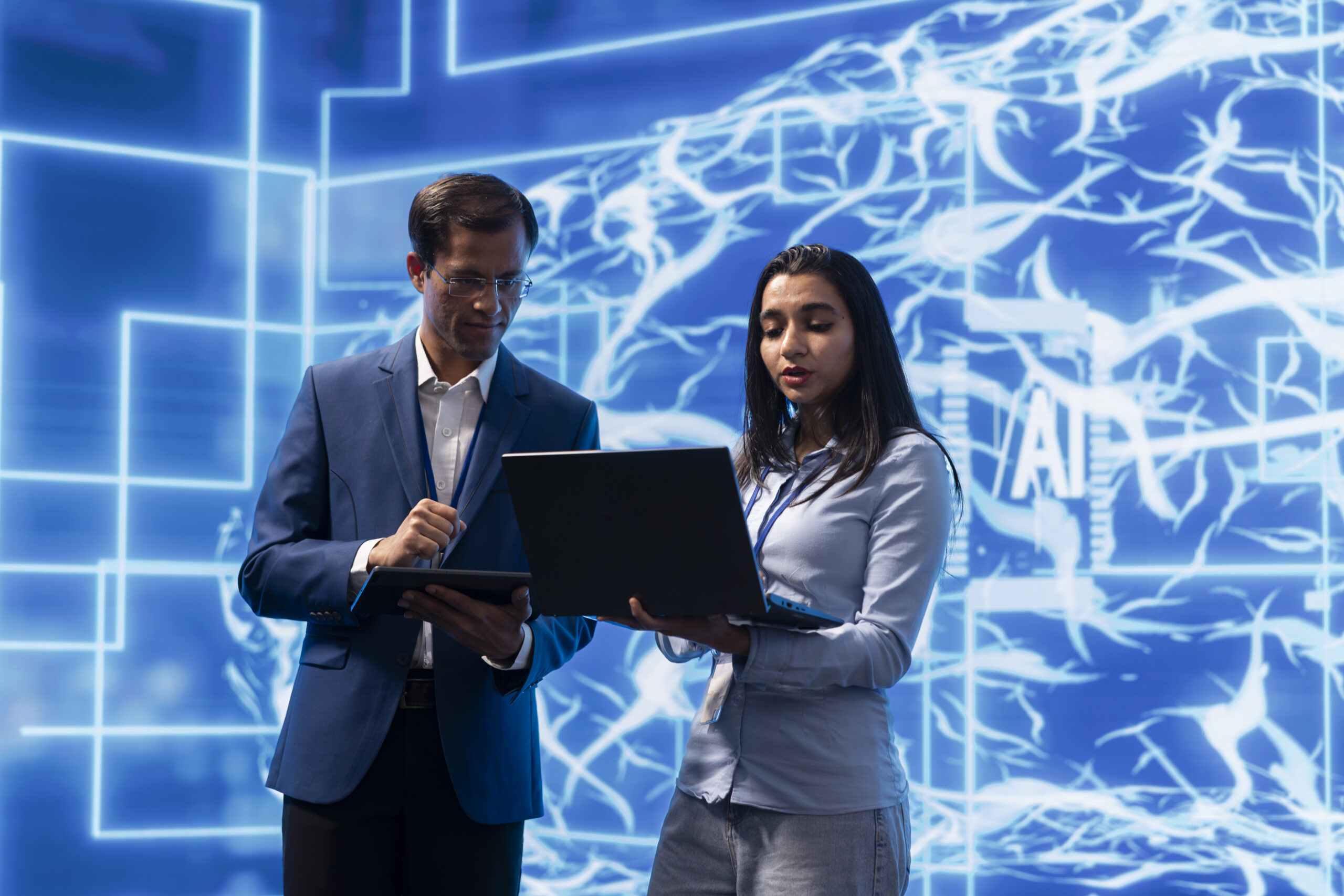 AI researcher and colleague working with artificial intelligence neural networks modern lab. Computer scientists collaborating on developing AI system in high tech workplace